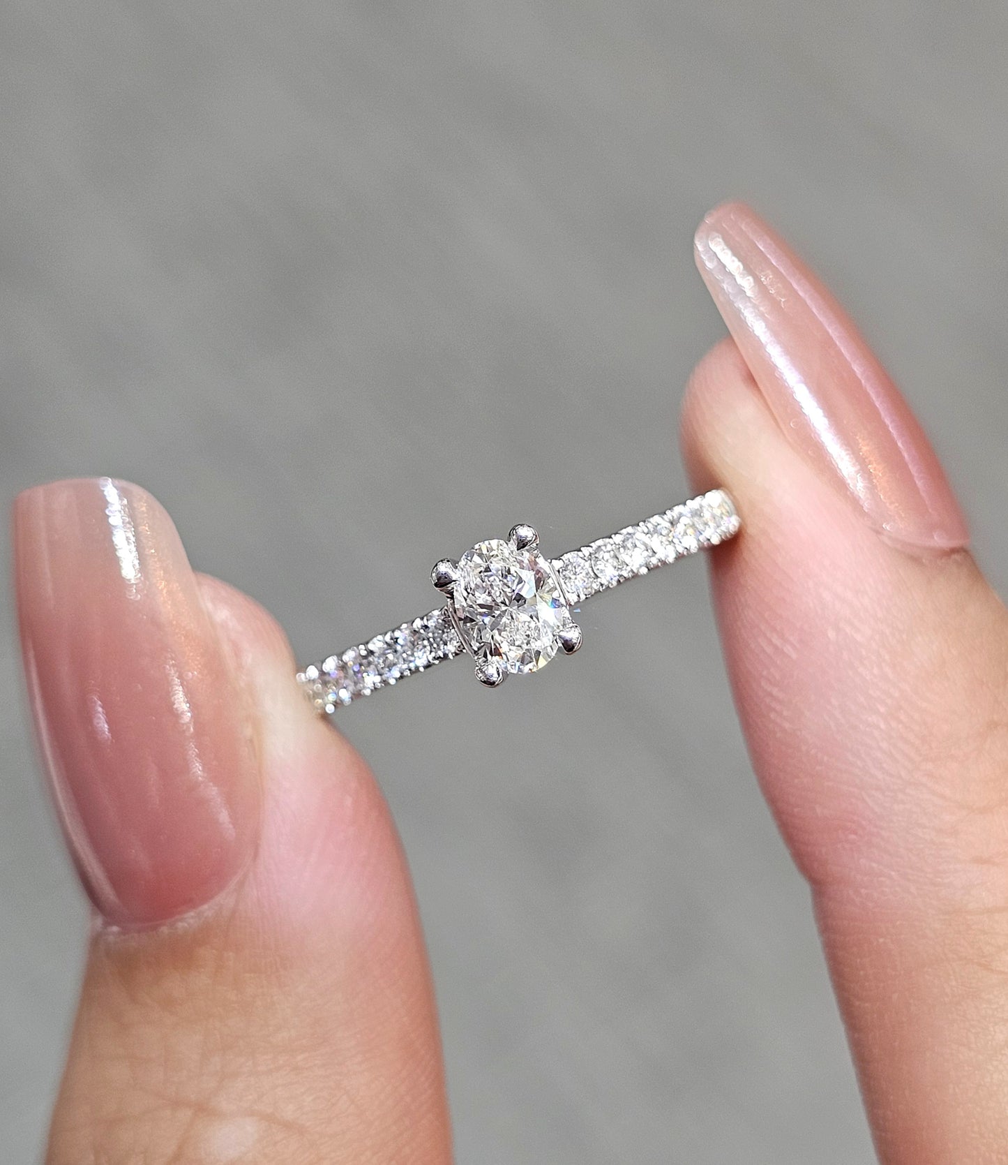 Close-up Oval Cut natural diamond engagement ring with pavé diamond band by S.Diamond