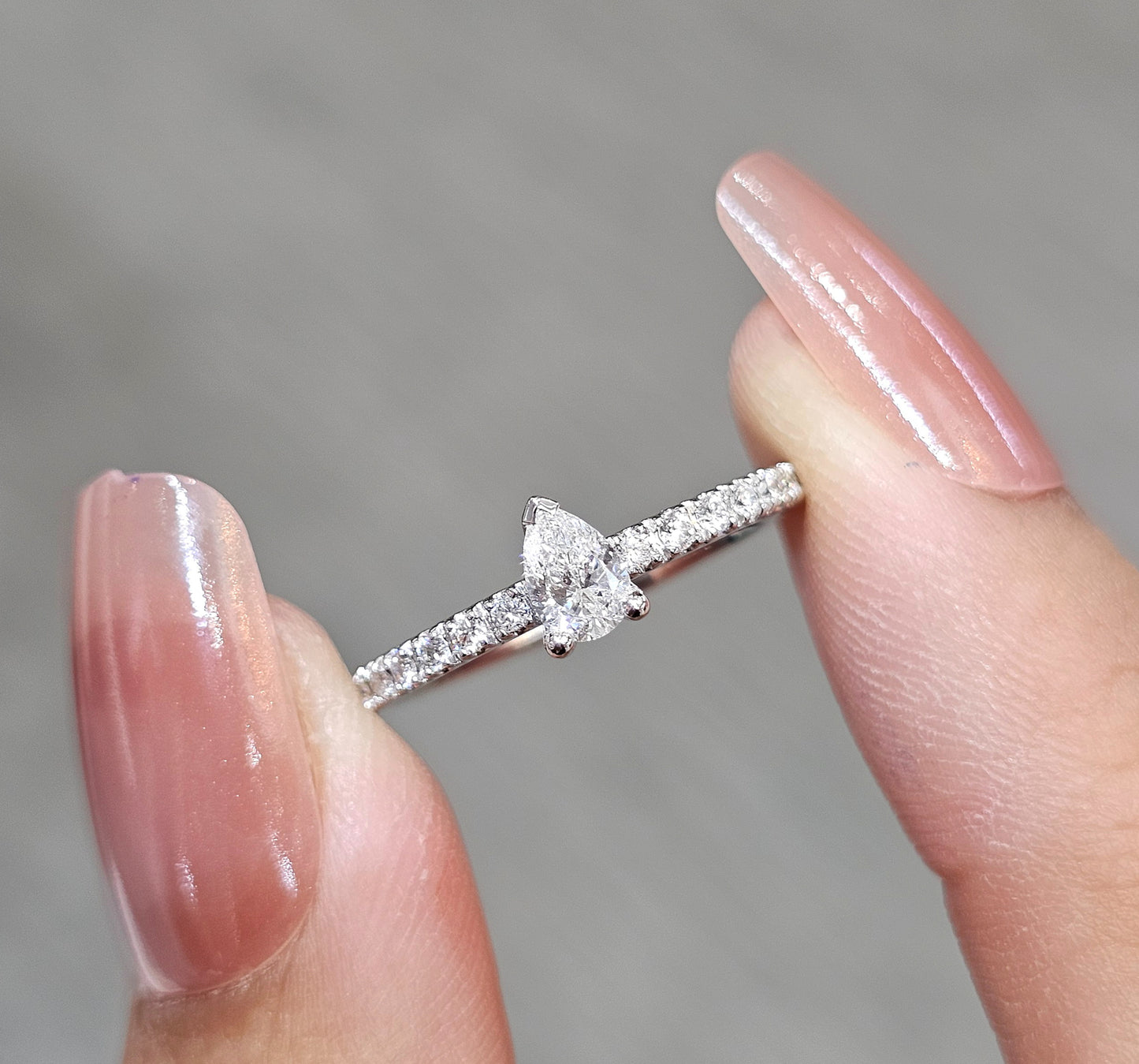 Close-up Pear Cut diamond engagement ring with pavé diamond band by S.Diamond