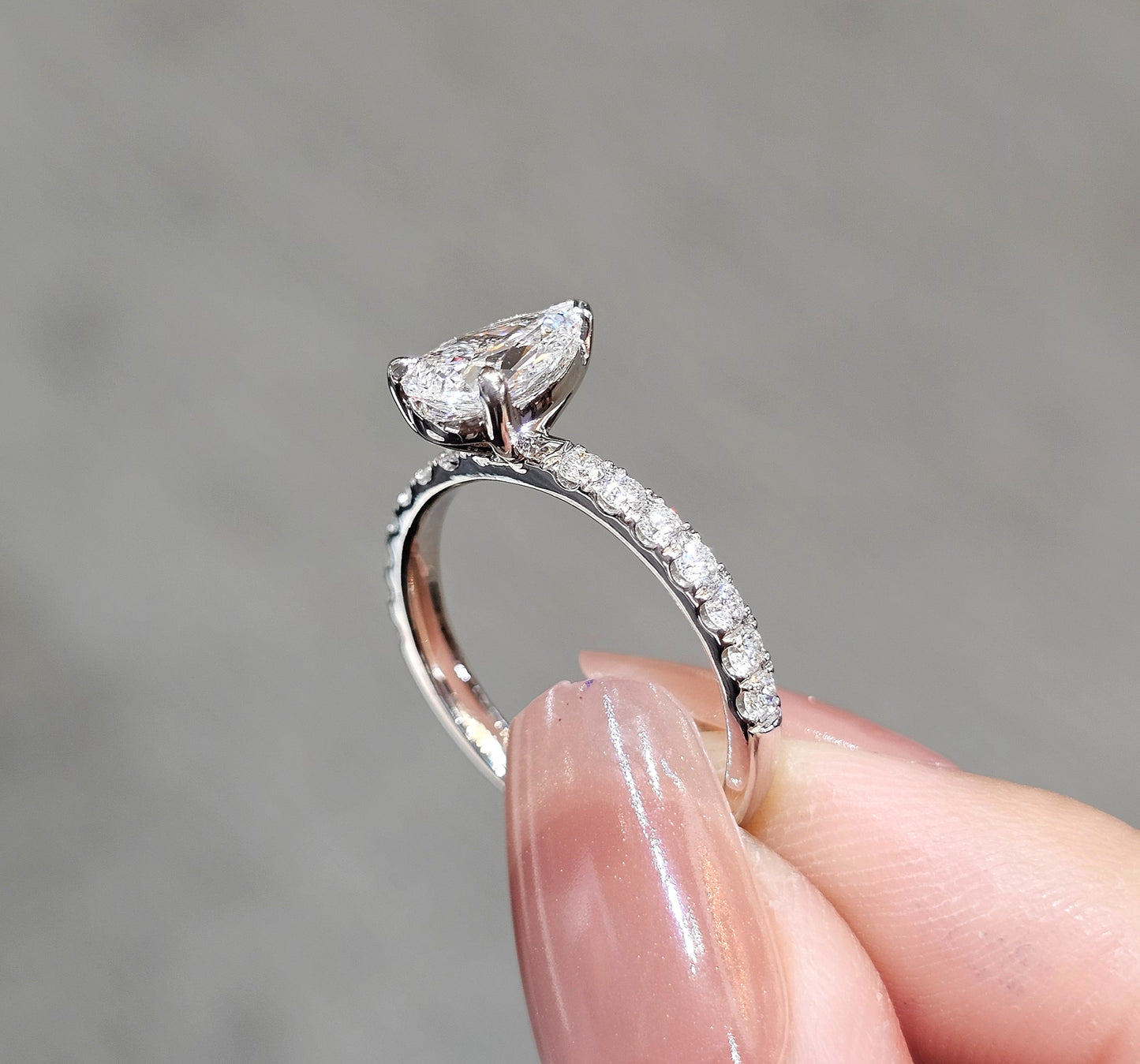 Close-up Pear Cut natural diamond engagement ring with pavé diamond band by S.Diamond