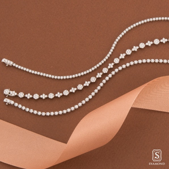 Rhythmic everyday diamond tennis bracelets stack featuring classic round, floral cluster, and modern square-set designs by S.Diamon